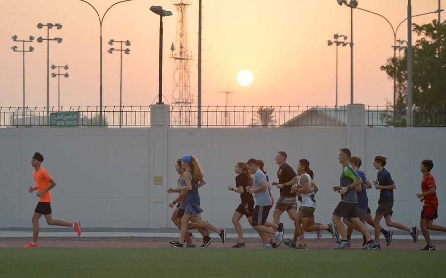 Cross country athletes run a warm-up lap around the track in Bahrain  on Thursday, Oct. 3, 2019. 