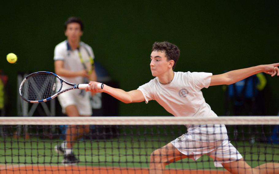 Marymount’s David Lopez Post stretches to return a shot in a boys doubles match against Kaiserslautern at the DODEA-Europe tennis championships in Wiesbaden, Germany, Thursday, Oct. 24, 2019. In the background, teammate Sergio Nogales watches the action.