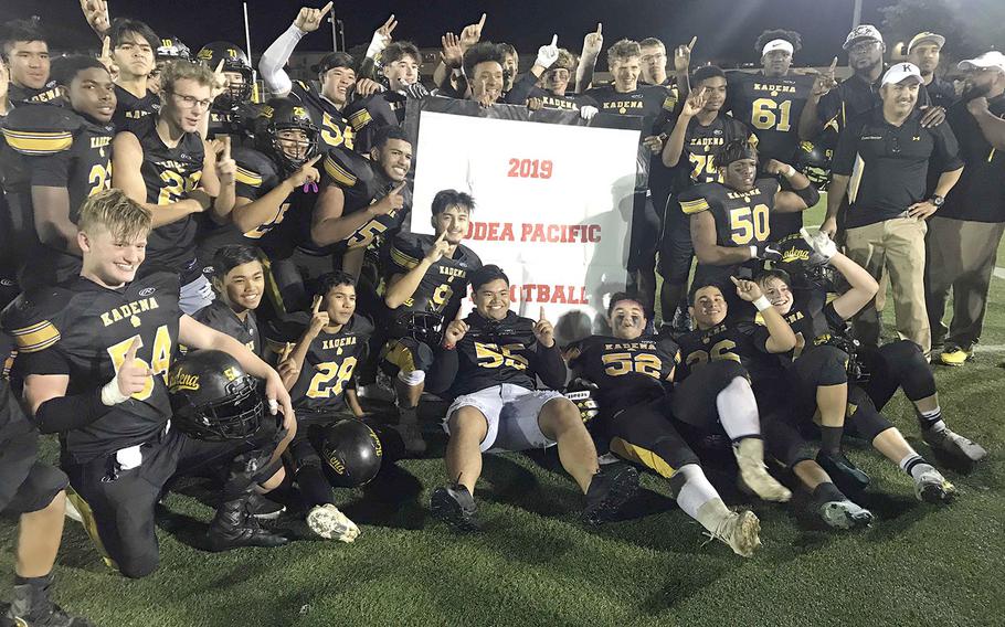 Kadena players and coaches gather round the victory banner.