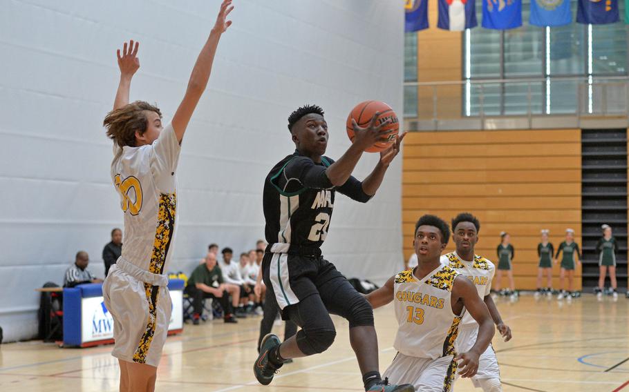 Naples' Ti Hunter aims for the basket as he splits the Vicenza defense of Trent Sayler, left, and Joseph Spencer in a Division II game at the DODEA-Europe basketball championships in Wiesbaden, Germany, Wednesday, Feb. 19, 2020. Naples won 59-55.