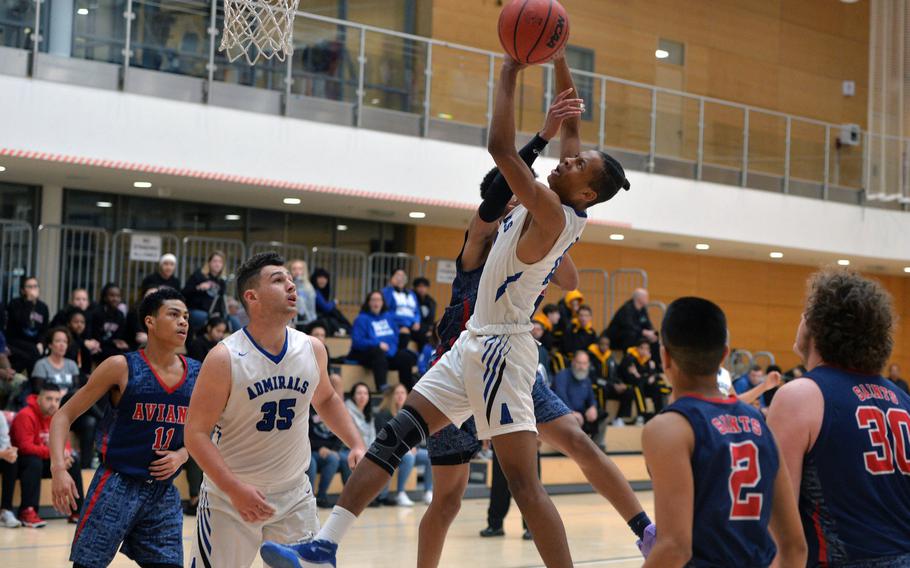 Teammates watch as Michael Tate shoots against Aviano's Malachai Brooks in a Division II game at the DODEA-Europe basketball championships in Wiesbaden, Germany, Wednesday, Feb. 19, 2020. Aviano won 48-39.