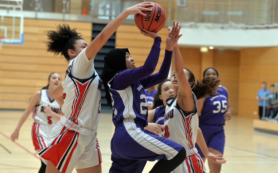 Aviano's Keyona Williams, left, and Mikyla Harkley try to stop Bahrain's Taz Abdkhair from scoring in a Division II game at the DODEA-Europe basketball championships in Wiesbaden, Germany, Wednesday, Feb. 19, 2020. Abdkhair was fouled on the play. Aviano beat Bahrain 30-12.