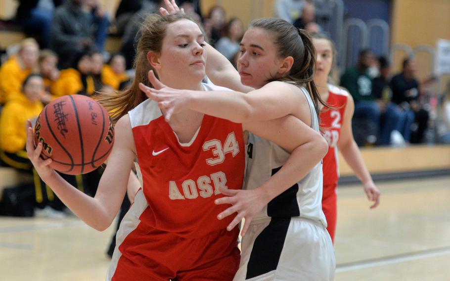 AOSR's Evan Park look for a teammate to pass to as Vicenza's Kate Hunter defends in a Division II game at the DODEA-Europe basketball championships in Wiesbaden, Germany, Wednesday, Feb. 19, 2020. Vicenza defeated AOSR 42-36.