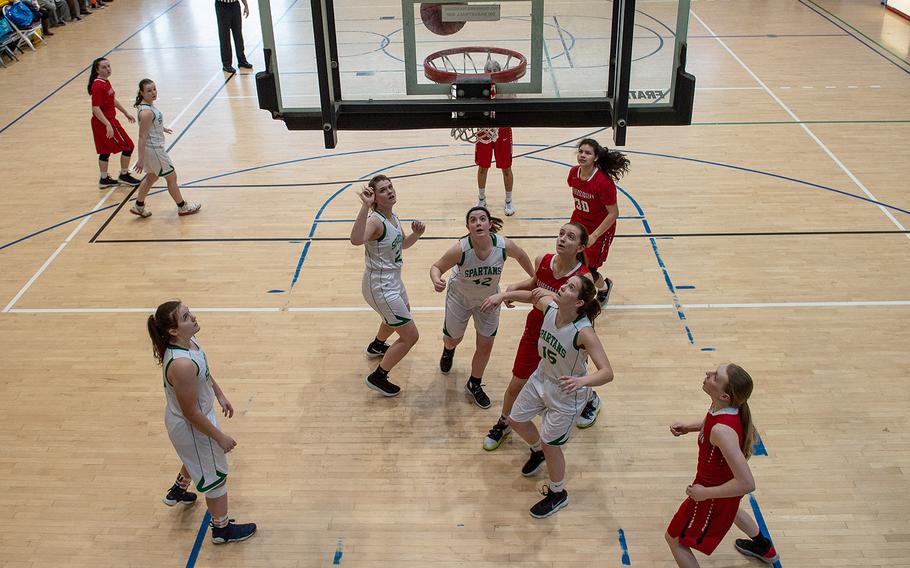 SHAPE players look up as Kaiserslautern player Audrey Elisondo's shot bounces through the hoop during the DODEA-Europe 2020 Division I basketball playoffs at the Southside gym on Ramstein Air Base, Germany, Wednesday, Feb. 19, 2020. 