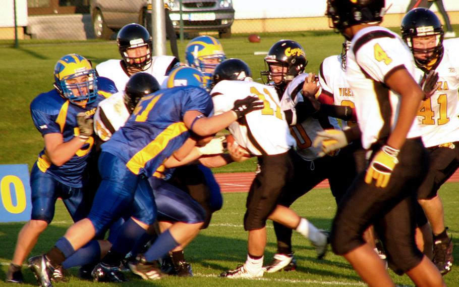 T.J. Propp (51) and Matt Jones lead the defensive charge against Vicenza quarterback Joe Boswell (11) Friday night at Katterbach, Germany, during Ansbach’s 36-6 Division II-South victory in the 2010 season opener for both teams. Also pictured are Ansbach’s Alex Moya (left) and Vicenza’s Marcus Grice (4) and Aaron Hogg (41).