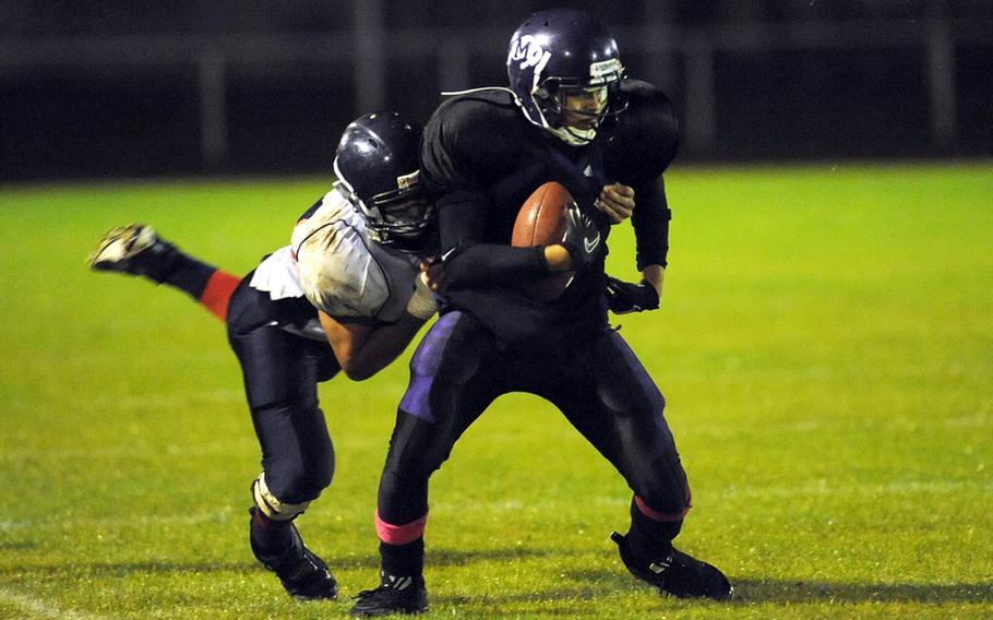 Bitburg's Austin Schmidt, left, makes a flying tackle on Mannheim's Calvin Baisden, as Bitburg defeated Mannheim, 21-6, in Mannheim Friday night.