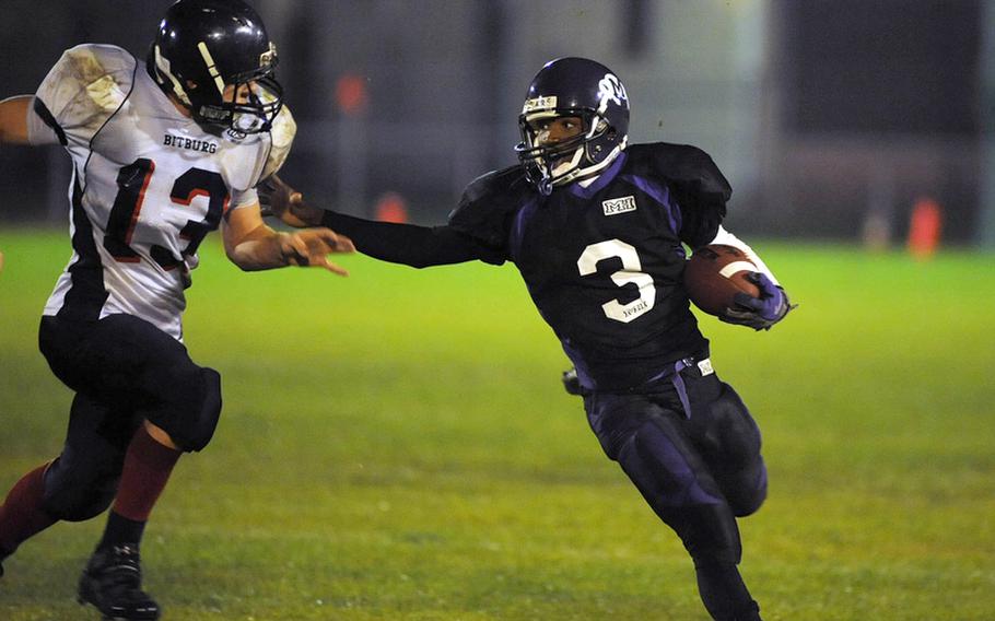 Mannheim's Aaron Garrision keeps Bitburg's Kyle Edgar at arm's length in Mannheim's 21-6 loss to the Barons Friday night. Garrison later scored the lone Bison touchdown.