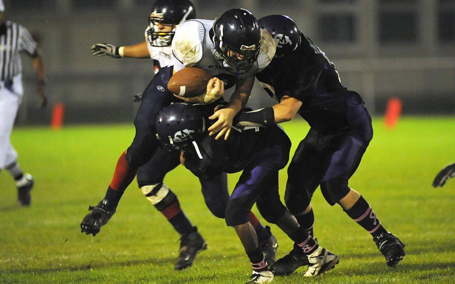 A hard hit by Mannheim's LaJuarren Burks and Kurtis Beeson knocks the ball out of the hands of Bitburg's Kyle Edgar in a Division II game in Mannheim Friday night. Edgar recovered his fumble and his Barons went on to defeat the Bison 21-6.