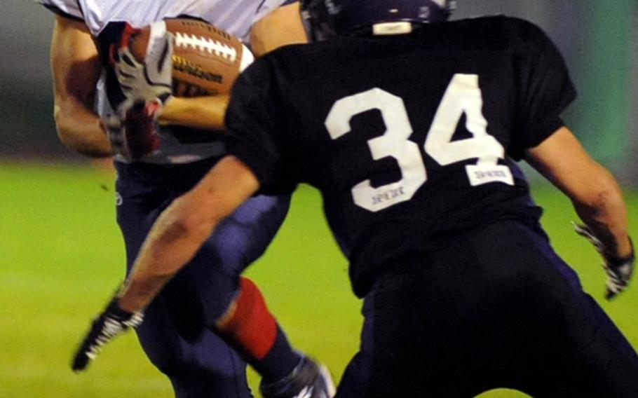 Bitburg's Erick Matos Jr. , left, tries to avoid being tackled by Mannheim's Chance Bullard in a Division II game at Mannheim on Friday night. The visiting Barons defeated the Bison 21-6, to stay undefeated.