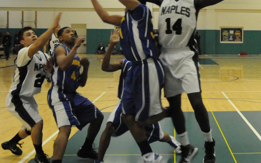 Naples center Nigel Alexander breaks up a pass Friday in the Wildcats' 72-39 victory over Sigonella as players for both teams get ready to fight for the ball.