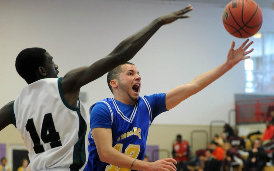 Ansbach's David Mendez, right, takes it it the hoop past Jamal Williams of Naples. Naples beat Ansbach, 44-34, in opening day Division II action at the DODDS Europe basketball championships in Mannheim, Germany.