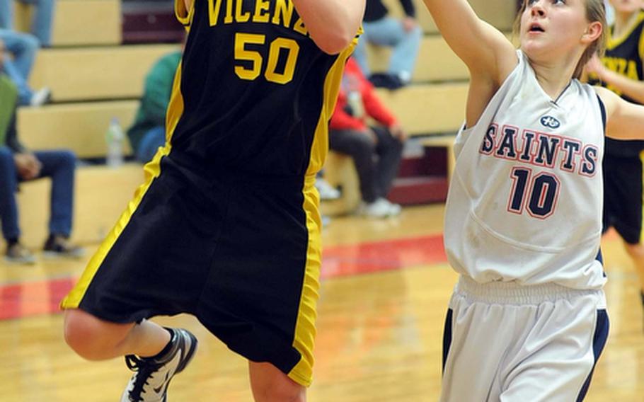 Vicenza's Sella Pauling scores the game's final basket ahead of Aviano's Alex Ostler as the sixth-seeded Lady Cougars beat the top-seeded Lady Saints, 64-48, to advance the the Division II finals on Saturday.