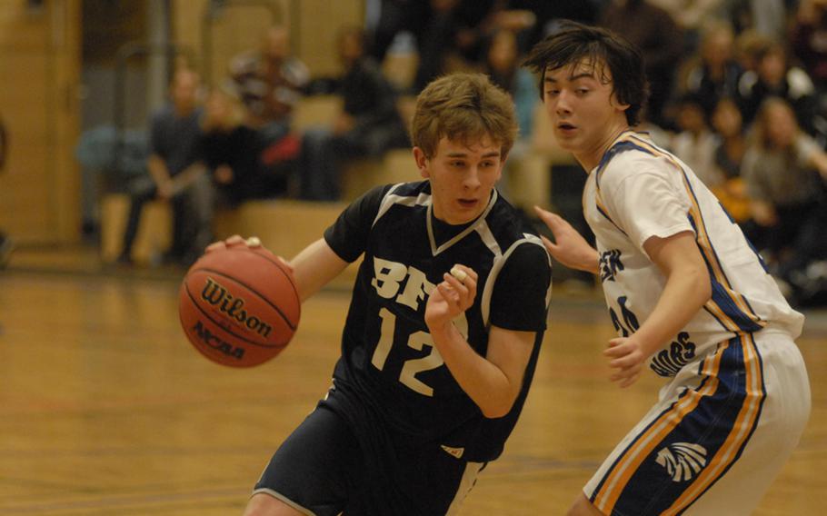 Black Forest Academy junior Joseph Leavitt drives to the bucket while Wiesbaden sophomore John Arnold tries to slow him down during a Friday night matchup between the Falcons and Warriors.