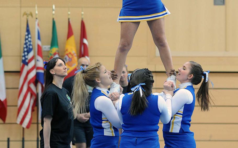 The Sigonella cheer team performs a stunt at the DODDS-Europe cheerleading championships.
