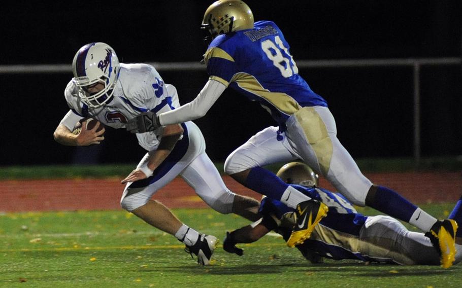 Ramstein quarterback Dylan Le Page, left, leaps towards the goal line, getting out of the reach of Wiesbaden's Jeremy Colon-Rios, center, and Jessie Davis, on his way to scoring his second TD of the game in the Royals' 14-0 win over the Warriors in Wiesbaden, Friday night. 