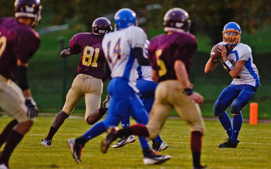 Sigonella's Collin Gantt drops back to pass in Saturday night's DODDS-Europe Division III playoff game against Baumholder.