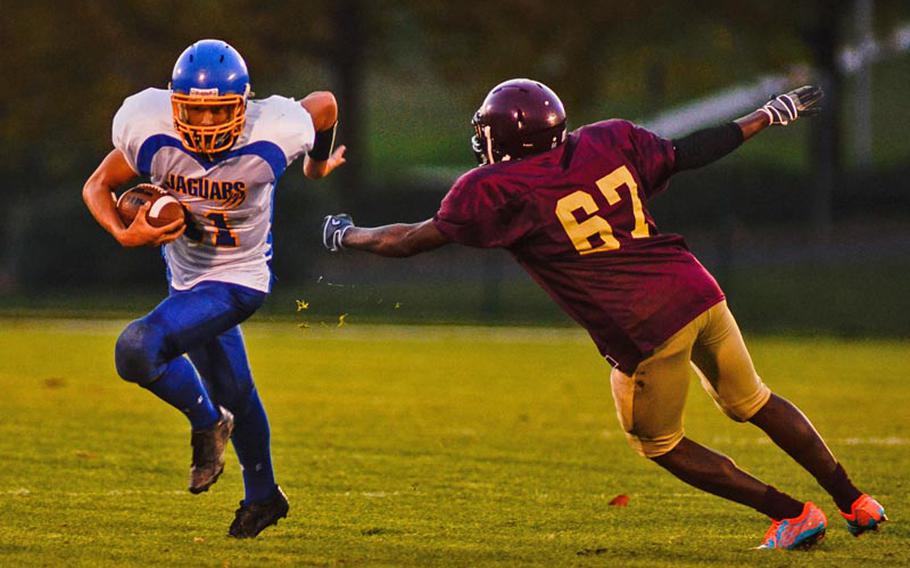 Sigonella's Collin Gantt gets by Baumholder's Dasante' Browne in Saturday night's 42-14 DODDS-Europe Division III playoff loss Baumholder.