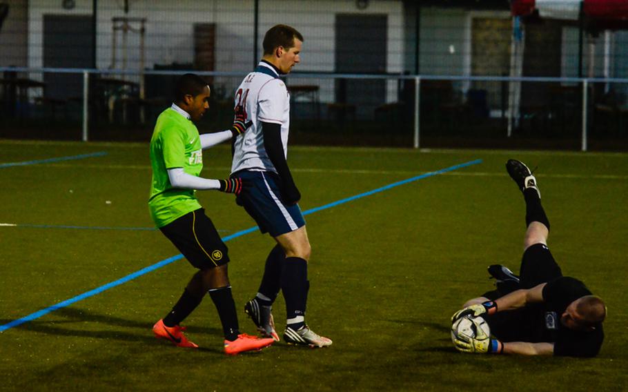 Vicenza's goalie, Shawn Durcan, dives for the ball helping his teammate Mathew Boshardt as Ramstein's Schyler Baxter tried to score Oct. 28, 2012, in Wiesbaden, Germany.