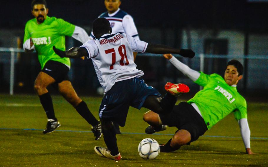 Vicenza's Jose Villareal takes a shot on goal as Ramstein's Everado Gomez tries to make a slide tackle Oct. 28, 2012, in Wiesbaden, Germany. Ramstein won the U.S. Forces Europe soccer championship after an overtime and a shootout. 