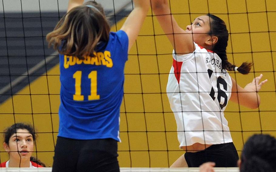 Schweinfurt's Maria Maika gets the ball over the outstretched hands of Ansbach's Duplessie Lauren in a Division II match at the DODDS-Europe volleyball championships. Ansbach won the match 25-22, 25-9.