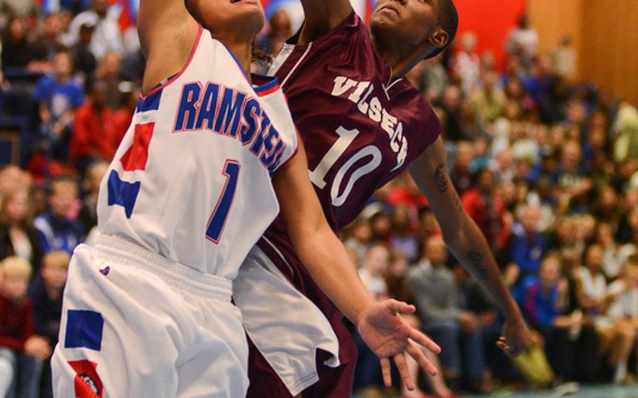 Ramstein High School's Breanna Martinez is blocked and fouled by Vilseck High School's China Sumpter Friday night as Ramstein defeated Vilseck at Ramstein Air Base.