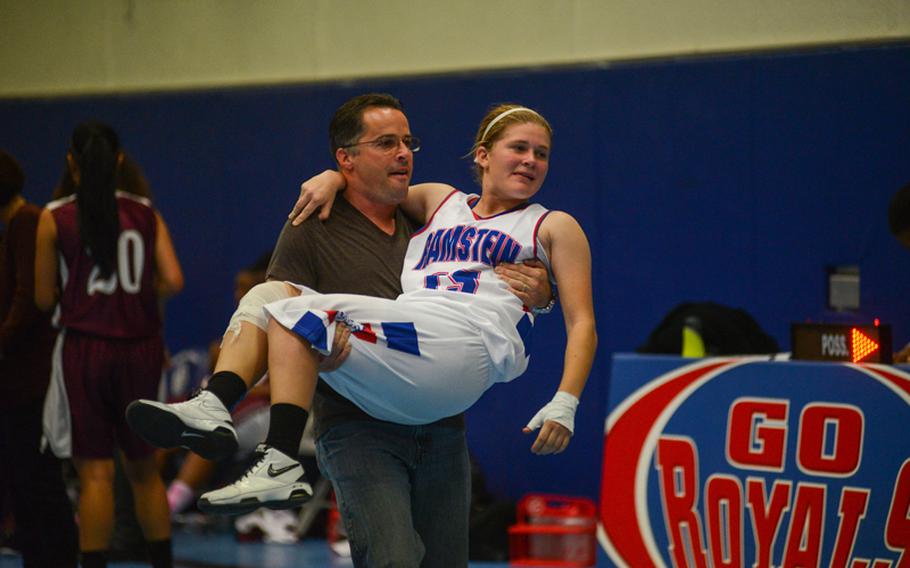 Ramstein High School's Dominique Dubois is carried to her team's bench by her father, David Dubois, Friday night as her team defeated Vilseck High School at Ramstein Air Base.