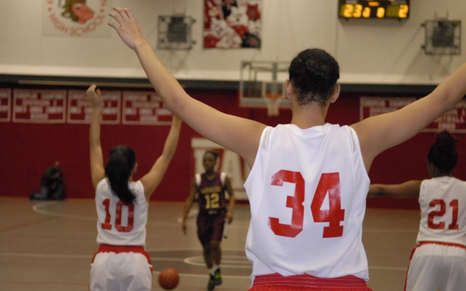 Kaiserslautern players raise their arms on defense during the girls' high school basketball game in Kaiserslautern on Friday night. The Red Raiders beat Baumholder 41-6.