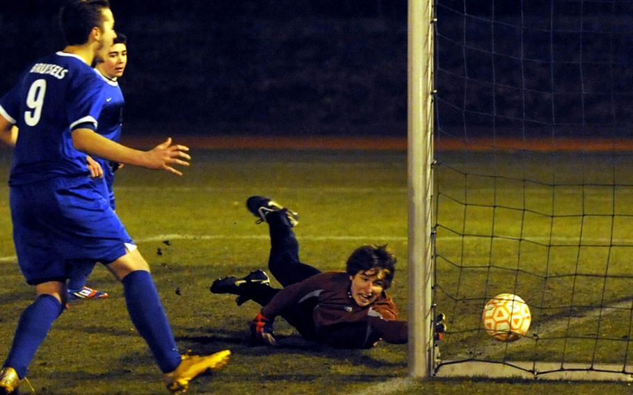 Nicholas Marinich, left,  watches as Brussels keeper Danny Helbling tries in vain to reach the game-winning shot as the host AFNORTH Lions defeated Brussels 5-4 in the season opener for both teams Thursday night.