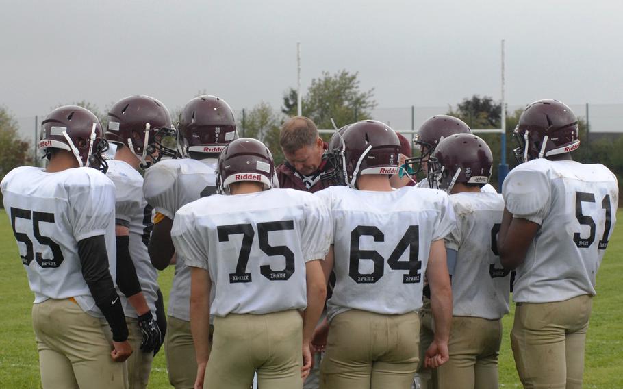 Baumholder head coach BJ Walker huddles with his team during a game stoppage Saturday at Bitburg, Germany. Bitburg won the game 42-6 and set a new DODDS-Europe record with its 32nd consecutive victory.