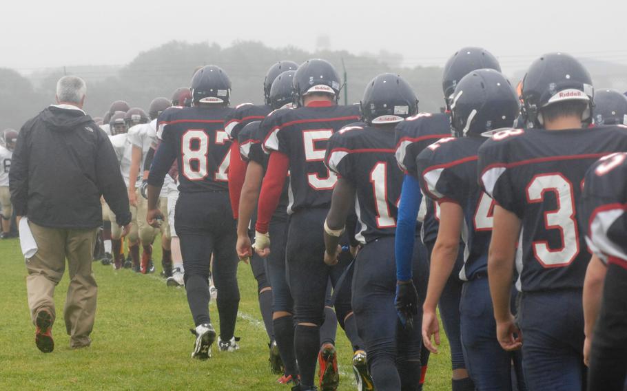 Bitburg coach Mike Laue leads his team across the field to shake hands with defeated Baumholder on Saturday at Bitburg, Germany. Bitburg won the game 42-6 and set a new DODDS-Europe record with its 32nd consecutive victory. 