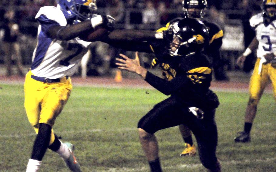 Ansbach senior Brian Debel stiff arms a Vicenza defender while picking up yardage in his team's 25-6 victory Friday night. Ansbach grabbed the top seed in the south division for the playoffs, which start next weekend.