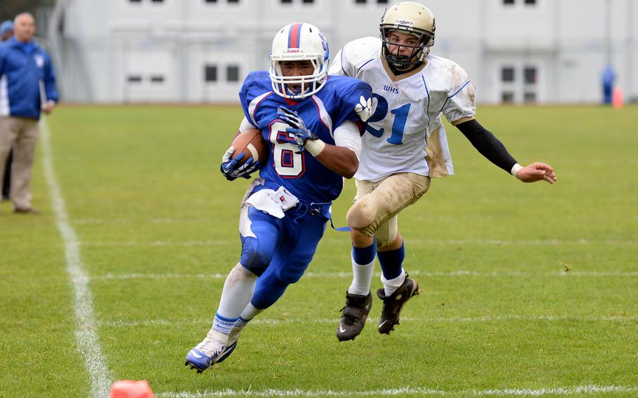 Ramstein's Robert Navarro races Wiesbaden's Johnathan Skeesick to the end zone for Ramstein's third touchdown of the day as Ramstein beat the visiting Warriors Saturday, Oct. 12, 2013, 20-7