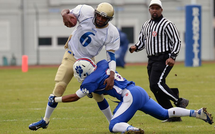 Ramstein's Robert Navarro, right, gets a hold on Reymoi Lewis after the Wiesbaden quarterback picked up some yardage.T he Royals beat Wiesbaden 20-7, Saturday, Oct. 12, 2013.