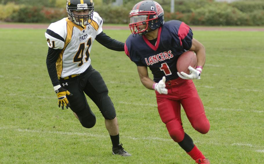 Lakenheath junior Deion Hall runs the ball ahead of Patch defender Jay Deal at RAF Lakenheath, England, during a game Saturday, Oct. 19, 2013. Lakenheath lost the game 28-27, to fnish a winless season.