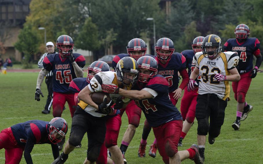 Patch sophomore Ethan Logan tries for more yardage against Lakenheath defenders, including junior Benjamin Ciero, Saturday, Oct. 19, 2013, during the two teams' final game of the regular season at RAF Lakenheath, England. Patch triumphed 28-27, after Lakenheath failed to make an extra-point kick at the end of the game.
