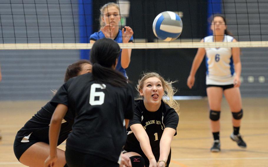 Bahrain's Krista Flores digs deep to try to return a Rota ball as teammates Jacklyn Payne, left, and Madison Belknap get in on the action, while Rota's Tayla Irby and Hailey Landry watch from across the net. Rota won the Division II game on opening day action at the DODDS-Europe volleyball championships, 25-13, 25-11.