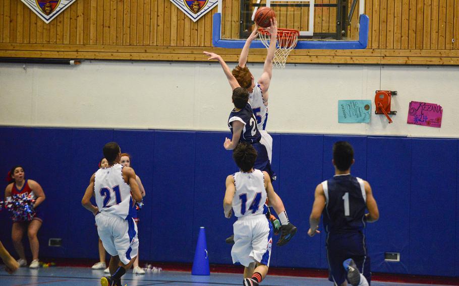 Ramstein's Drew Tevebaugh goes up for a contested two-handed dunk just in front of Bitburg's Colton Thomas Friday night at Ramstein, Germany.