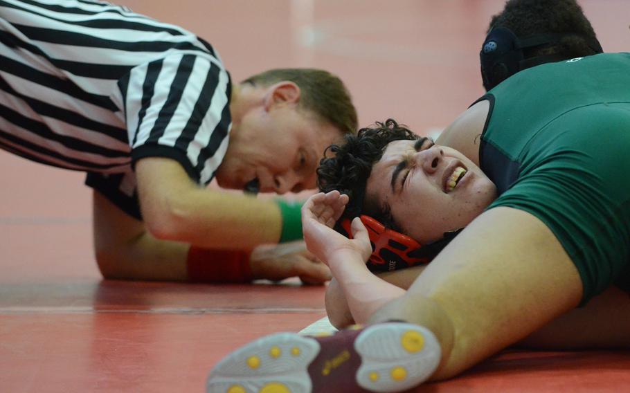 Referee Jon Ward brings his hand down to smack the mat as Naples' Kory McKinney pins Emil Jurgens of American Overseas School of Rome Saturday, during a 170-pound wrestling match at Aviano Air Base, Italy.