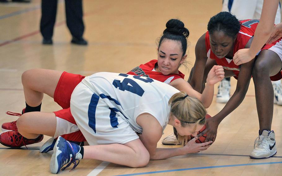 Black Forest Academy's Brianne Riffe, fights for the ball against Bamberg/Schweinfurt's Ariana Diaz and Tierney Houston, right, in BFA's 46-12 win in opening day girls Division II action at the DODDS-Europe basketball championships in Wiesbaden, Germany, Wednesday, Feb. 19, 2014.
