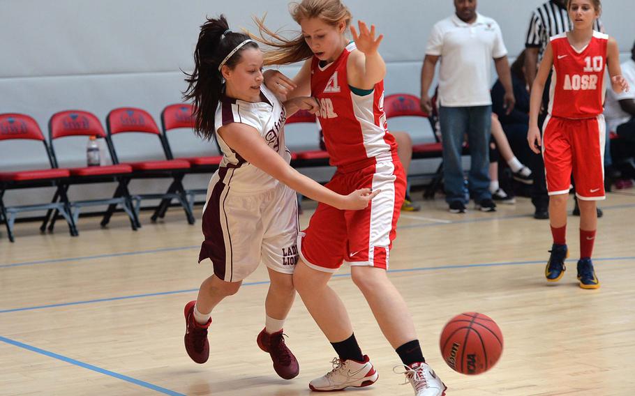 AFNORTH's Jena Solorzano gets a bounce pass off to a teammate against American Overseas School of Rome's Alison Cook in girls Division II action at the DODDS-Europe basketball championships in Wiesbaden, Germany, Wednesday, Feb. 19, 2014. AFNORTH defeated AOSR 32-6.