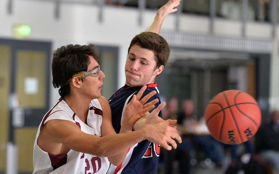 AFNORTH's Berk Dikici passes off to a teammate as Aviano's Alex Slabaugh tries to defend in Division II action at the DODDS-Europe basketball championships in Wiesbaden, Germany, Wednesday, Feb. 19, 2014. AFNORTH defeated Aviano 60-25.