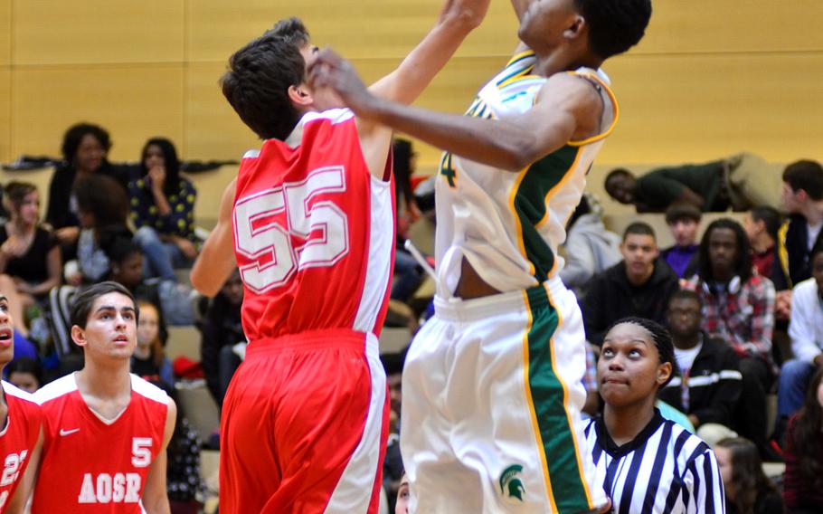 American Overseas School of Rome senior Felix Kristensson goes head-to-head against SHAPE junior Armond Griebe at the game's tip-off during the 2014 DODDS-Europe basketball championships in Wiesbaden, Germany, Wednesday, Feb. 19, 2014.
