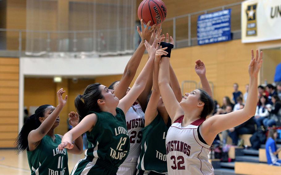 A multitude of Menwith Hill and Ankara players try to pull down a rebound in Division III action at the DODDS-Europe basketball championships in Wiesbaden, Germany, Thursday Feb. 20, 2014. From left are Isabel Burns, Denise Culbreath, Diane Kim and Ramie Ogea, while Ankara's Nani Khumalo watches at far left. The Mustangs defeated Ankara 24-5.