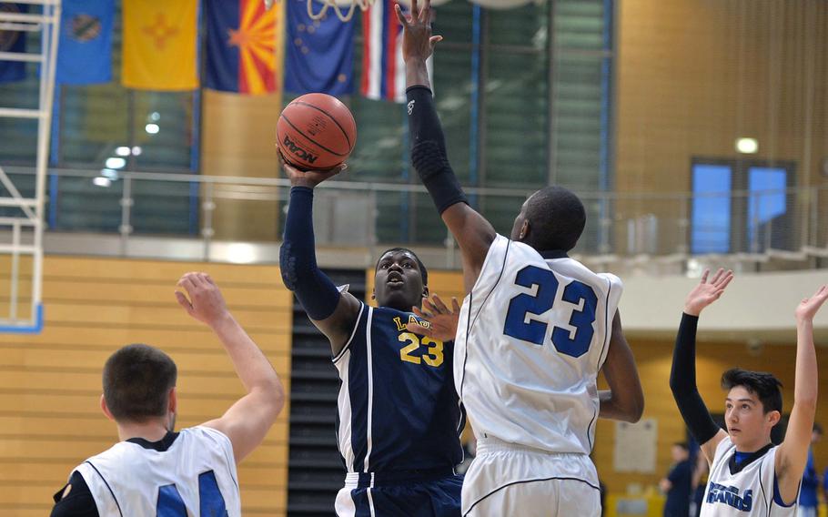 Marlon Hawkins of Lajes takes a shot against Javaughn Harrison of Brussels in evening Division III action at the DODDS-Europe basketball championships in Wiesbaden, Germany, Thursday Feb. 20, 2014. At left is Matt Broulx, at right Merab Chitanava. Brussels won 54-21.