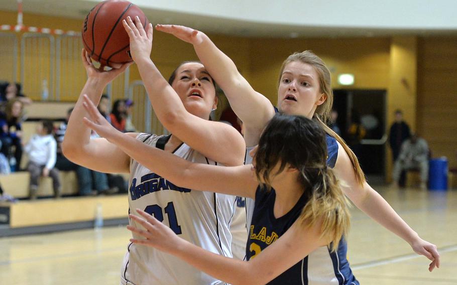 Despite the defense of Lajes' Enneleise Hirak, center and Julia Czymbor, Brussels' Teodora Vasileva scores in evening Division III action at the DODDS-Europe basketball championships in Wiesbaden, Germany, Thursday Feb. 20, 2014.
