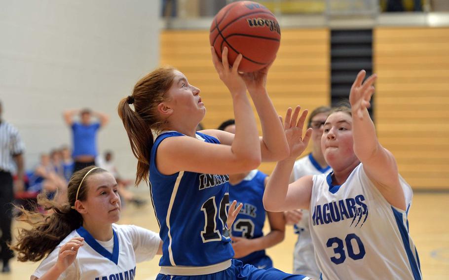 Incirlik's Kortney Taylor goes up for a shot against Sigonella's Michaela Bowling in a Division III semifinal at the DODDS-Europe basketball championships in Wiesbaden, Germany, Friday Feb. 21, 2014. Sigonella won the game 40-16 and will face Brussels in Saturday's final. At left is Katie Cauble.