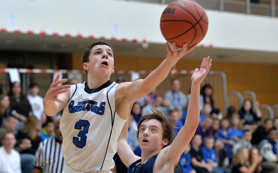 Michael DeFazio of Brussels looks to the basket after getting past Menwith Hill's Ian Evans in a Division III semifinal at the DODDS-Europe basketball championships in Wiesbaden, Germany, Friday Feb. 21, 2014. Brussels won 49-22 to advance to Saturday's final.