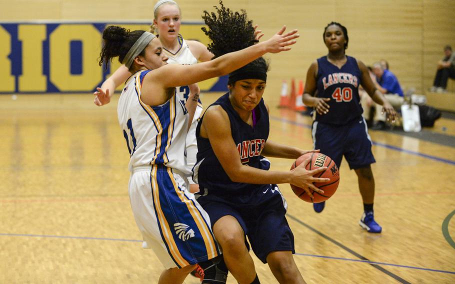 Lakenheath's Addie Ruffin takes the ball to the basket against Wiesbaden's Dominique Baldwin in a DODDS-Europe basketball championships Division I semifinal game Friday, Feb. 21, 2014 at Wiesbaden, Germany. Wiesbaden beat Lakenheath 33-26.