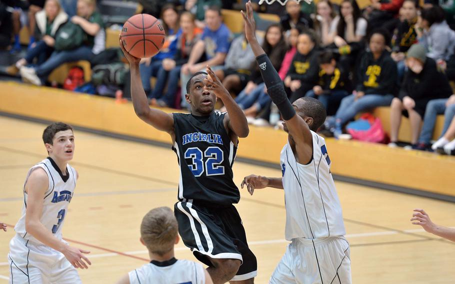 Incirlik's Cameron Little sails to the basket against Javaughn Harrison of Brussels in the Division III final at the DODDS-Europe basketball championships in Wiesbaden, Germany, Saturday, Feb. 22, 2014. Brussels won 41-33 to take the title.