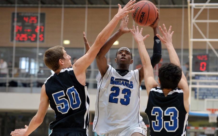 Javaughn Harrison of Brussels goes to the basket against Incirlik's Patrick Ostrand, left, and Ryan Packard in the Division III final at the DODDS-Europe basketball championships in Wiesbaden, Germany, Saturday, Feb. 22, 2014. Brussels won 41-33 to take the title. Harrison was named the tourney MVP for the division.